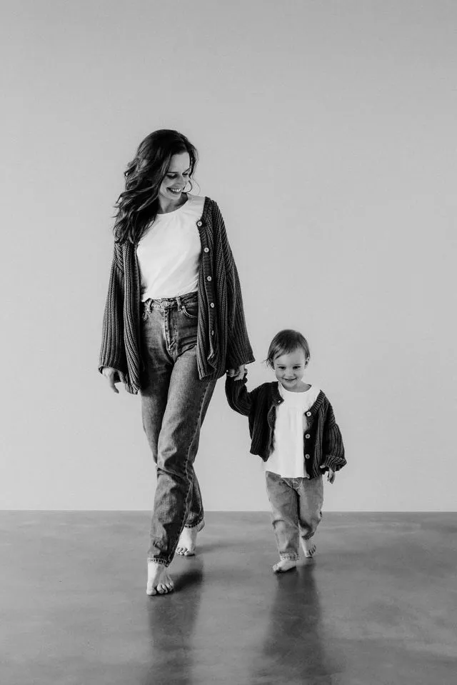 Žena a dieťa kráčajú spolu po podlahe